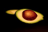 Avocado halves with seed isolated on black.