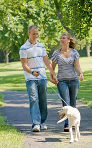 Young Couple Walking Dog