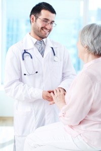 Confident doctor looking at his senior patient while speaking to her